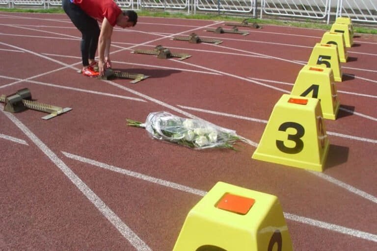 Atletický míting „Košice 2013“, GPS 4.mája Symbolická pietna kytica v dráhe číslo 3 pred štartom tretieho ročníka Memoriálu Mgr. Miroslava Chudého v behu na 100 m mužov, v dráhe č.4 si štartovné bloky pripravuje neskorší víťaz behu Oleg Danyliuk (11,01 s) z ukrajinského Ternopiľa