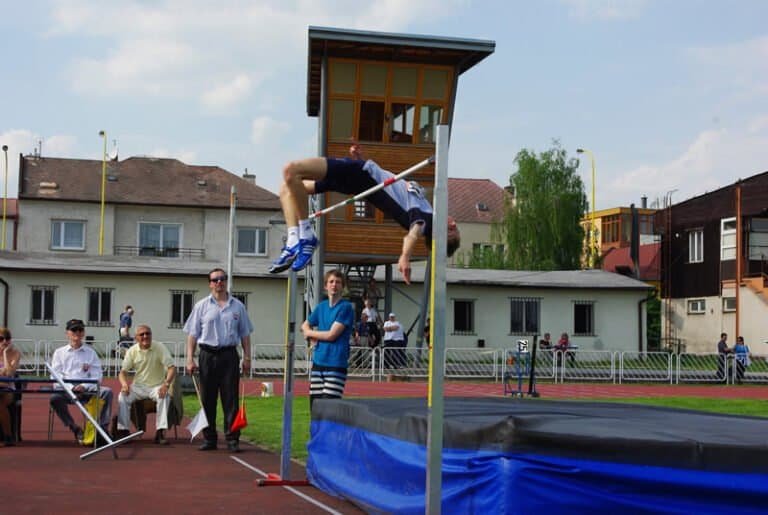 GPS Košice 2010, 1. mája Rozhodcovské zloženie súťaže výškarov: druhý zľava sediaci v bielej košeli Ladislav Pažák st., druhý sprava v stoji s vlajkami Slavomír Sekelský, obaja dlhoroční pretekári a rozhodcovia AO ATU. Nad latkou víťaz súťaže v skoku do výšky úspešný Košičan Lukáš Beer /20 r., z AK Olympia ŠG/ s výkonom 210 cm.